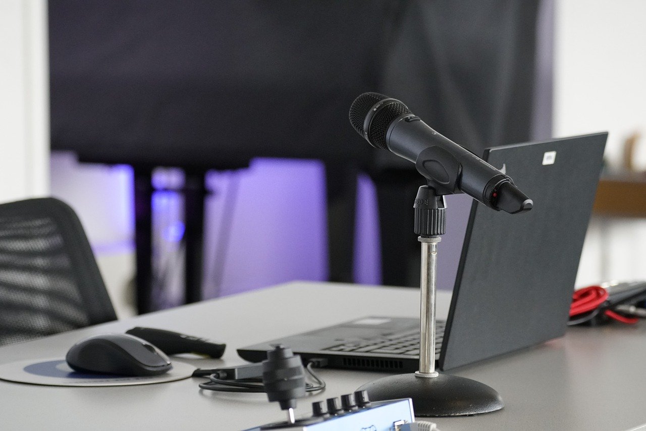 Microfono da podcast su scrivania con laptop, setup per podcast aziendali